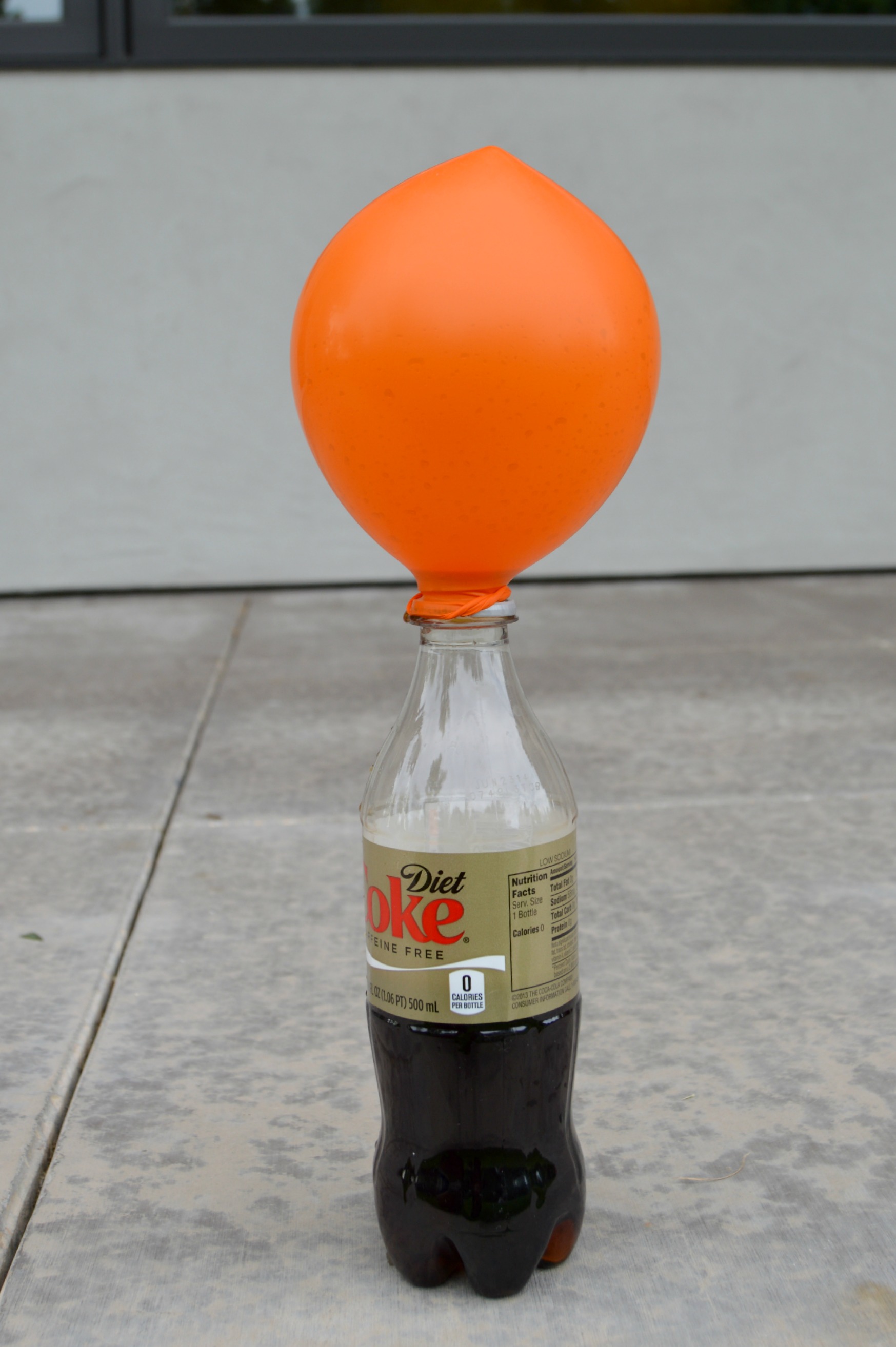 Balloon on top of a Diet Coke bottle 