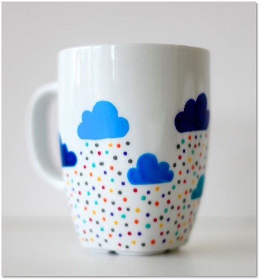 Image of a white mug with clouds painted on it 