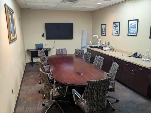 Conference room interior shot showing long conference table and smart television