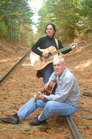 Andy and Judy posing on railroad tracks with instruments