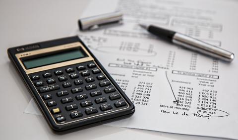 calculator, pen, and budget sheet